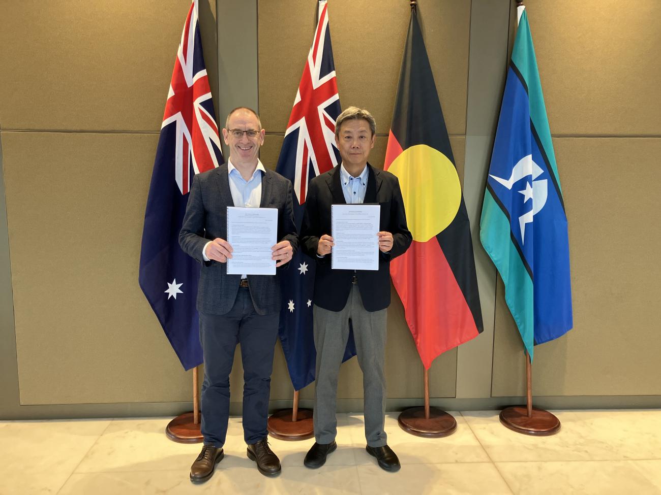 Peter Galvin (L) and Noriaki Sunohara (R) present the signed agreements